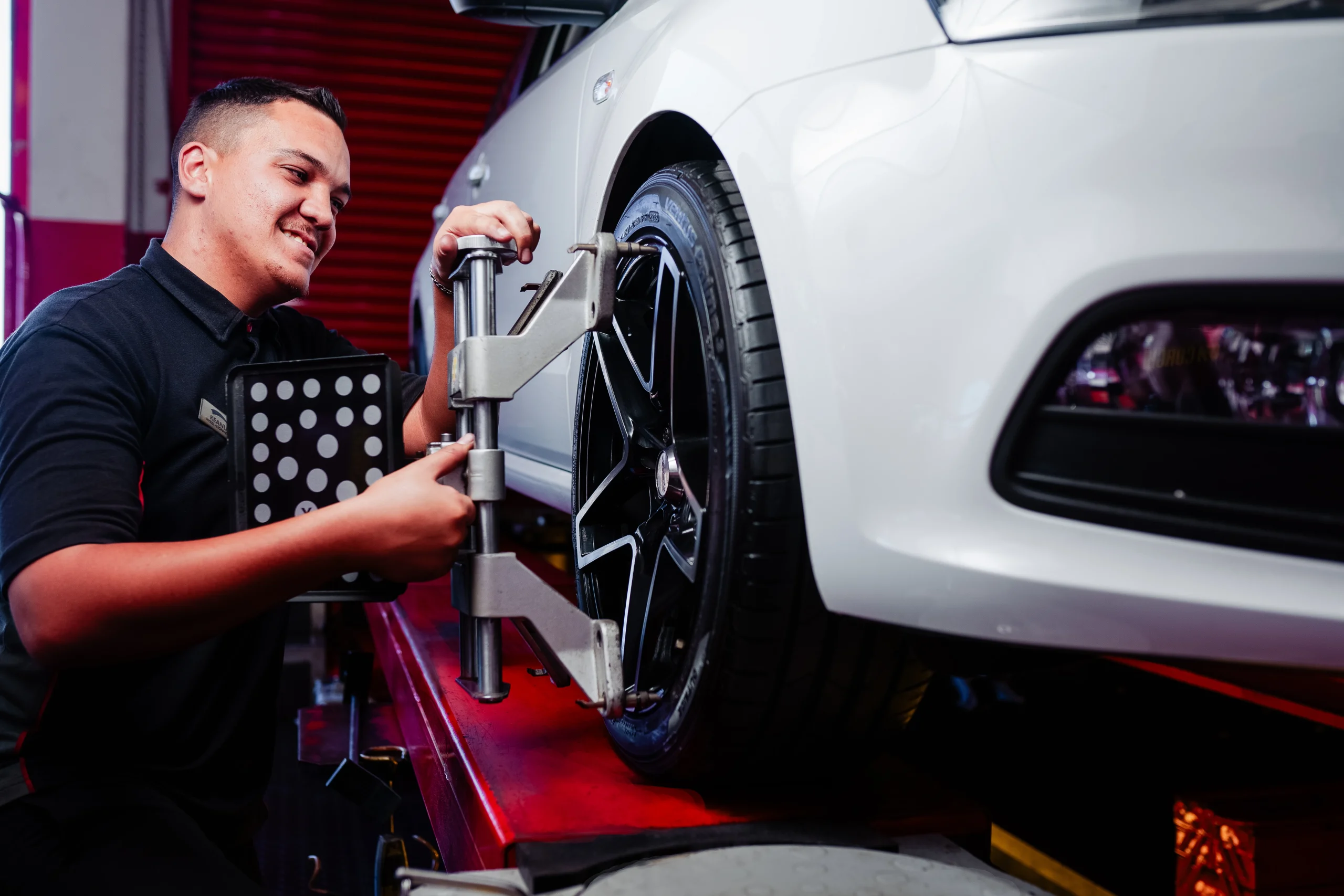 A Tiger Wheel & Tyre technician performing a Wheel Alignment & Balancing procedure